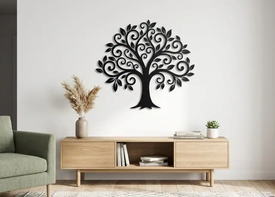 A stylish interior design photograph featuring a beautiful piece of custom wall art cut from 18-gauge steel. The metal art depicts an intricate tree silhouette, powder-coated in matte black, hanging against a clean white wall.
